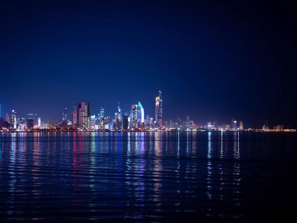 how much money do you need to live comfortably in Kuwait — Kuwait City skyline at dusk with the Kuwait Towers and modern residential district in the background