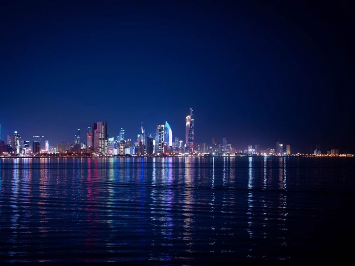 how much money do you need to live comfortably in Kuwait — Kuwait City skyline at dusk with the Kuwait Towers and modern residential district in the background